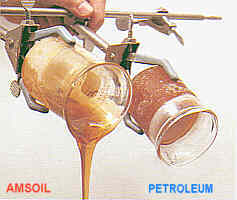Historic photo showing AMSOIL and petroleum oil pouring from beakers.